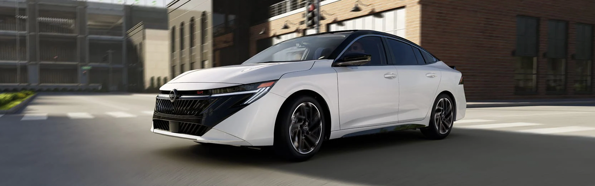 White Nissan sedan driving through the city.