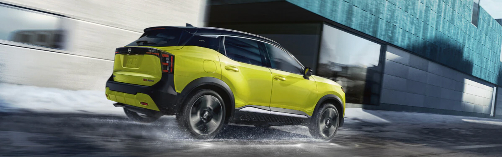 Green Nissan Kicks SUV in motion on a wet road.